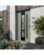 Moderne deur van groen roestvrij staal met een zwart frame rondom het glas